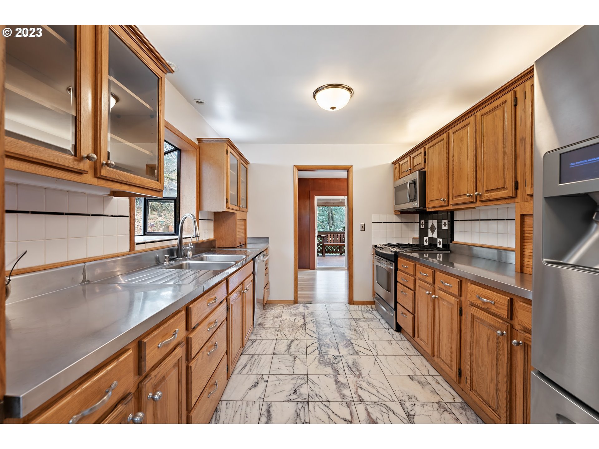 2435 Southwest Dakota Street Portland, OR 97239 - Photo 18 of 47 a kitchen with granite countertop a sink stove and cabinets