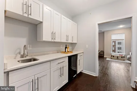 a kitchen with a sink cabinets and wooden floor