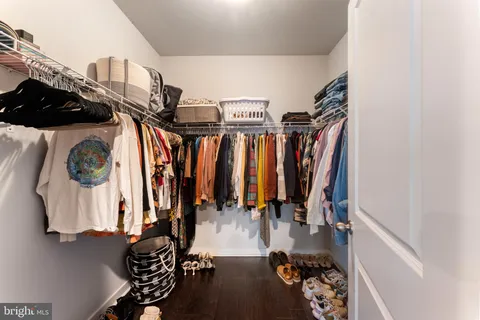 a view of walk in closet with clothes and shoes