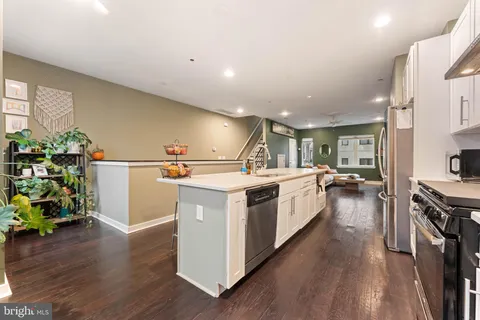 a kitchen with a sink stove and wooden floor