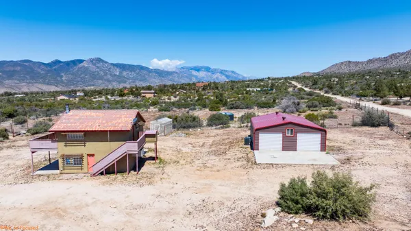 an aerial view of a house with a yard and mountain view