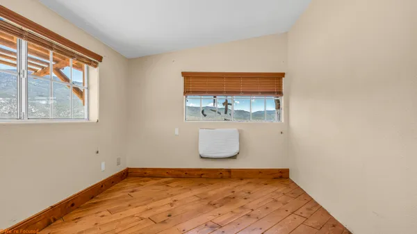 a view of a room with wooden floor and a window