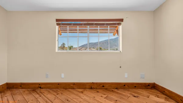 an empty room with wooden floor and a window