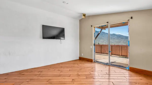 a view of a livingroom with wooden floor and a flat screen tv
