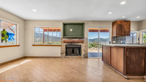 a view of kitchen with granite countertop stove top oven and refrigerator