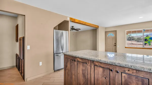 a kitchen with granite countertop a sink and refrigerator
