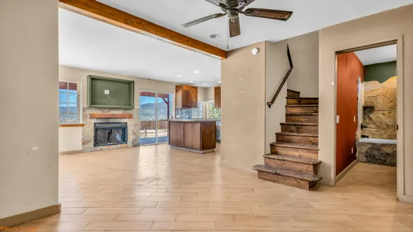 a view of a livingroom with furniture staircase and a ceiling fan
