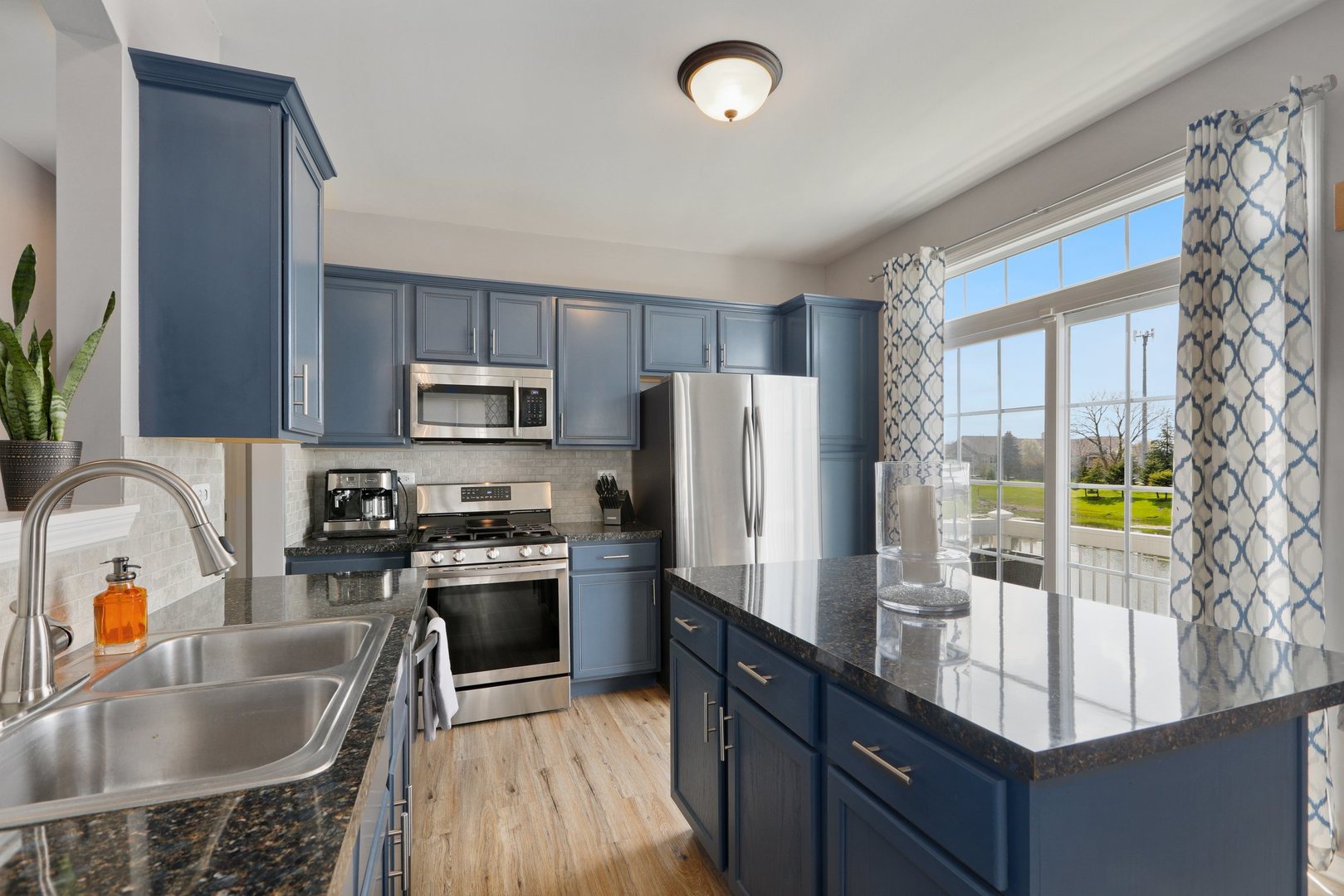 301 Timber Ridge Court Joliet, IL 60431 - Photo 6 of 17 a kitchen with granite countertop a sink a counter top space appliances and cabinets