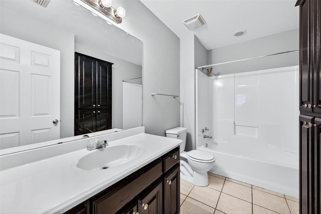 1021 Rice Street, Unit 101 Denison, TX 75020 - Photo 13 of 22 a bathroom with a double vanity sink toilet and shower