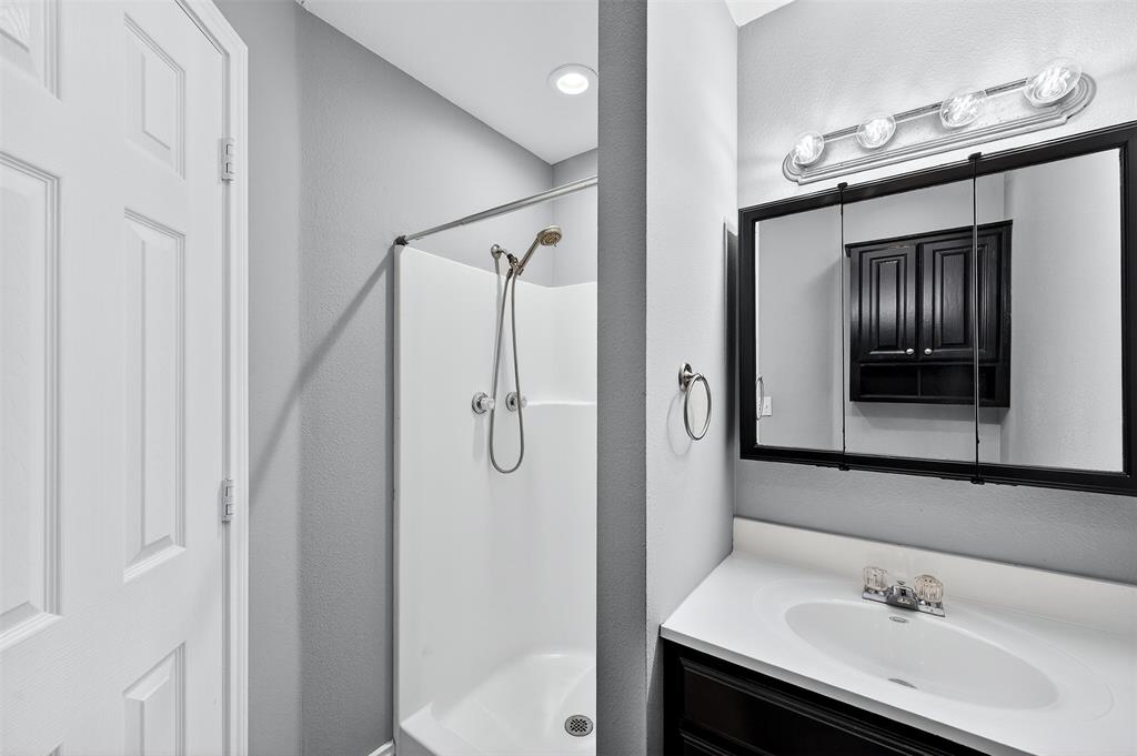 1021 Rice Street, Unit 101 Denison, TX 75020 - Photo 17 of 22 a bathroom with a sink and mirror