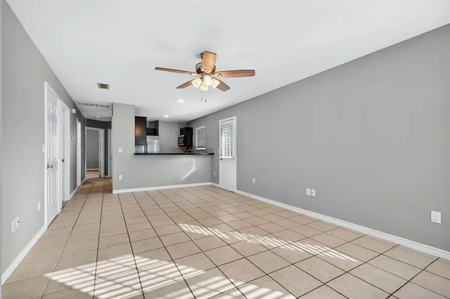 a view of a hallway with a chandelier fan and windows