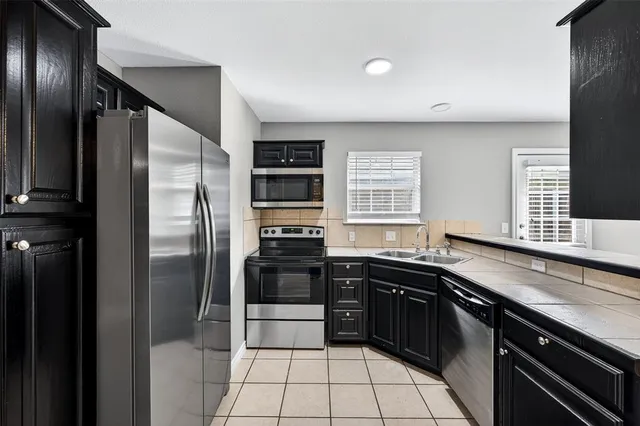 a kitchen with stainless steel appliances a sink stove and refrigerator