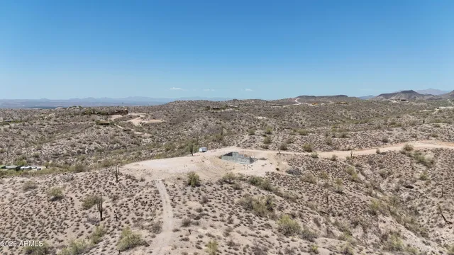 a view of a dry field with mountains in the background