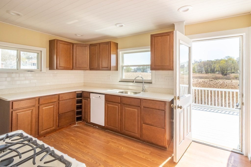 36 Ocean Avenue, Unit OCEAN VIEW Hull, MA 02045 - Photo 13 of 38 a kitchen with a sink window and cabinets
