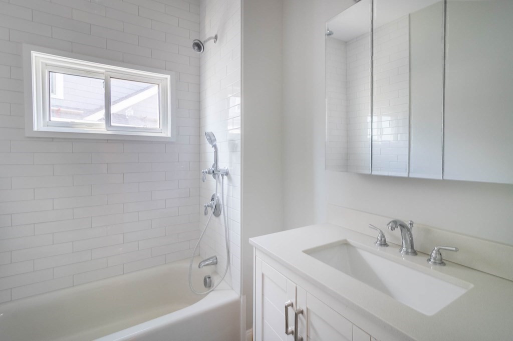 36 Ocean Avenue, Unit OCEAN VIEW Hull, MA 02045 - Photo 20 of 38 a bathroom with a sink vanity tub and a mirror