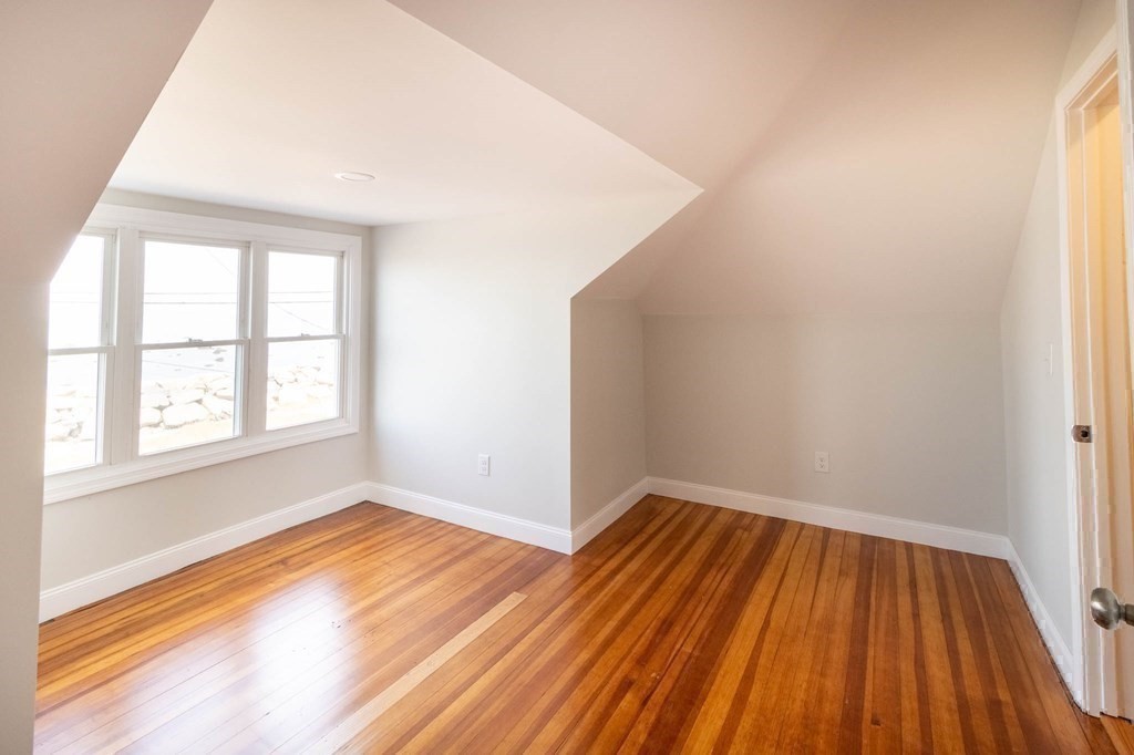 36 Ocean Avenue, Unit OCEAN VIEW Hull, MA 02045 - Photo 27 of 38 an empty room with wooden floor and windows