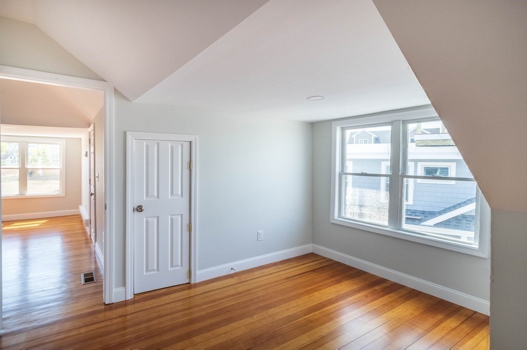 36 Ocean Avenue, Unit OCEAN VIEW Hull, MA 02045 - Photo 28 of 38 an empty room with wooden floor and windows