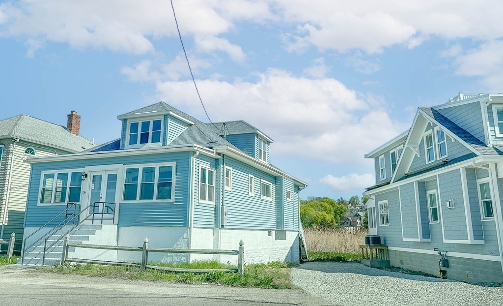 36 Ocean Avenue, Unit OCEAN VIEW Hull, MA 02045 - Photo 3 of 38 a view of a white house with large windows and a small yard