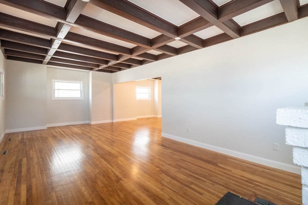36 Ocean Avenue, Unit OCEAN VIEW Hull, MA 02045 - Photo 8 of 38 a view of an empty room with wooden floor and a window