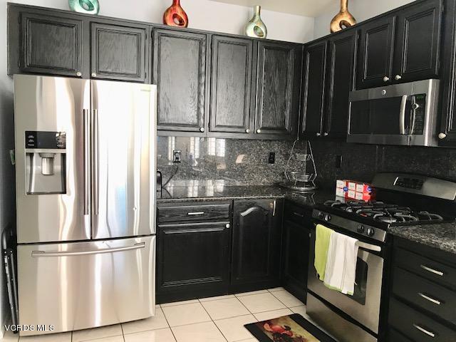 757 Navigator Way Oxnard, CA 93035 - Photo 7 of 23 a kitchen with granite countertop a refrigerator stove and microwave