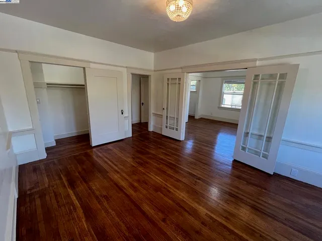 a view of empty room with wooden floor and window