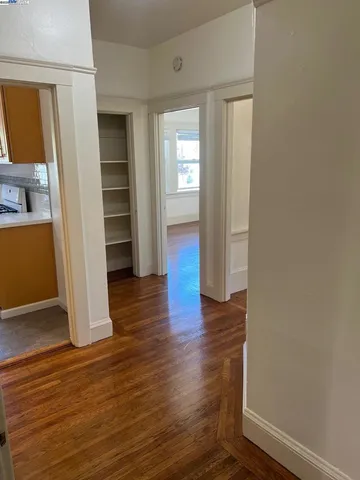 an empty room with wooden floor & windows and closet