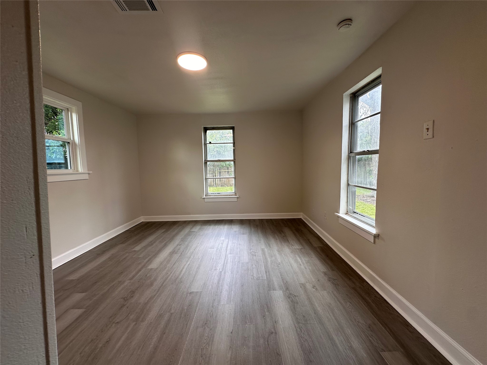 2516 Ivy Street Houston, TX 77026 - Photo 5 of 9 an empty room with wooden floor and windows