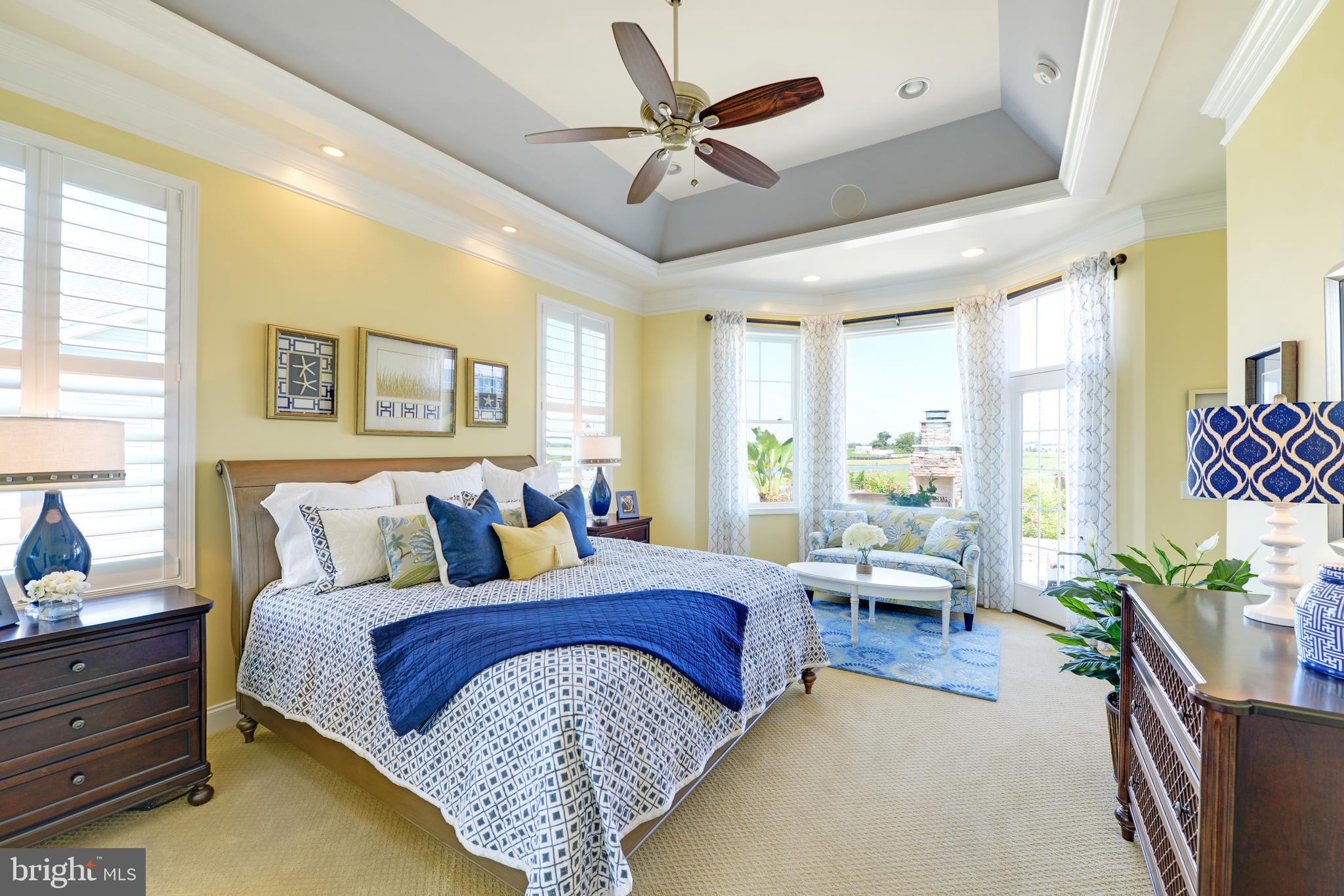 21785 Eastbridge Loop Lewes, DE 19958 - Photo 13 of 14 a spacious bedroom with a bed a chandelier and a potted plant