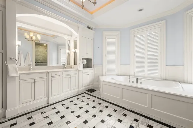 a spacious bathroom with a double vanity sink a mirror and a bathtub