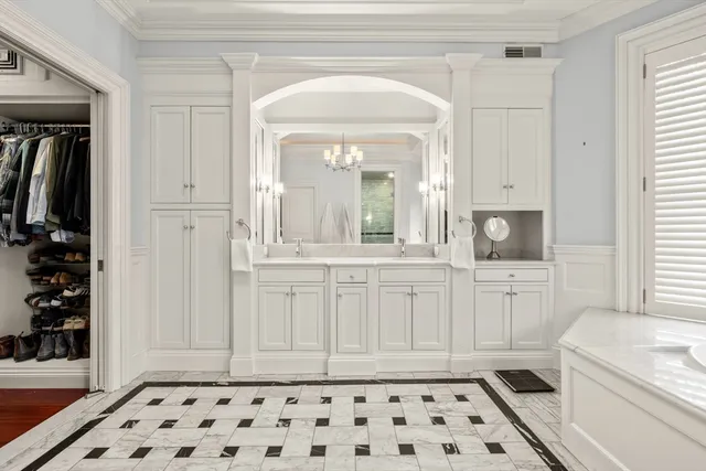 a room with a white cabinets a sink and a window