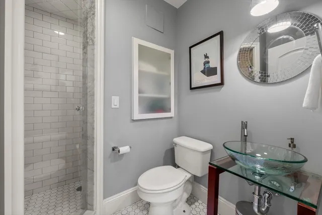 a bathroom with a granite countertop sink a toilet and a mirror