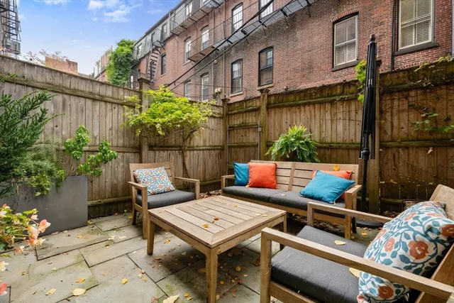 a view of a patio with a table and chairs and potted plants