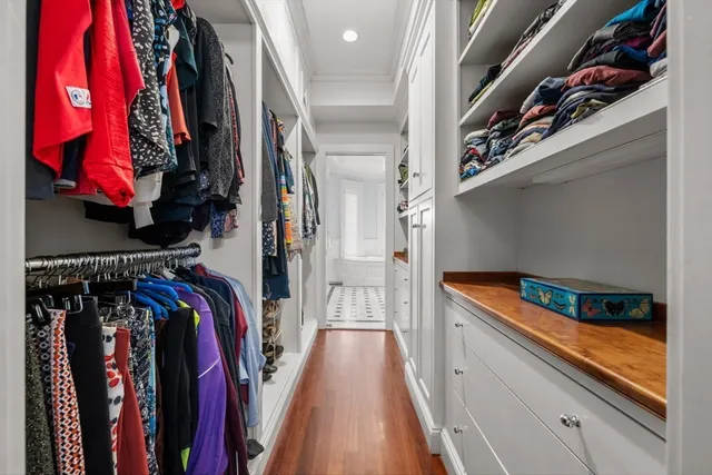 a view of walk in closet with clothes and shoes