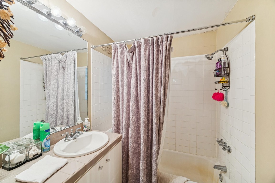 4207 Drake Street Houston, TX 77005 - Photo 21 of 24 This full bathroom features a clean, functional layout with a fully tiled tub and shower enclosure, an extended vanity, and updated lighting. Neutral finishes and durable materials support easy maintenance while appealing to a wide range of tenants.