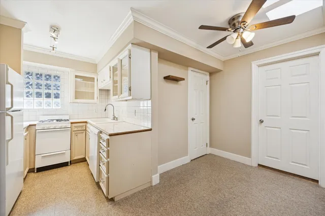 a kitchen with white cabinets and white appliances