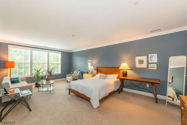 a bedroom with a bed and a large window