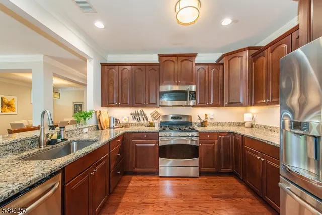 a kitchen with stainless steel appliances granite countertop a sink stove and refrigerator