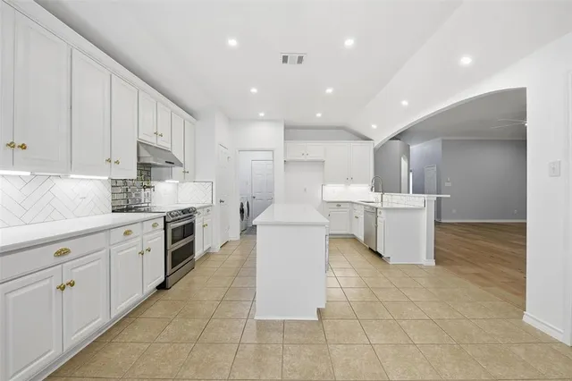 a kitchen with a sink and white cabinets