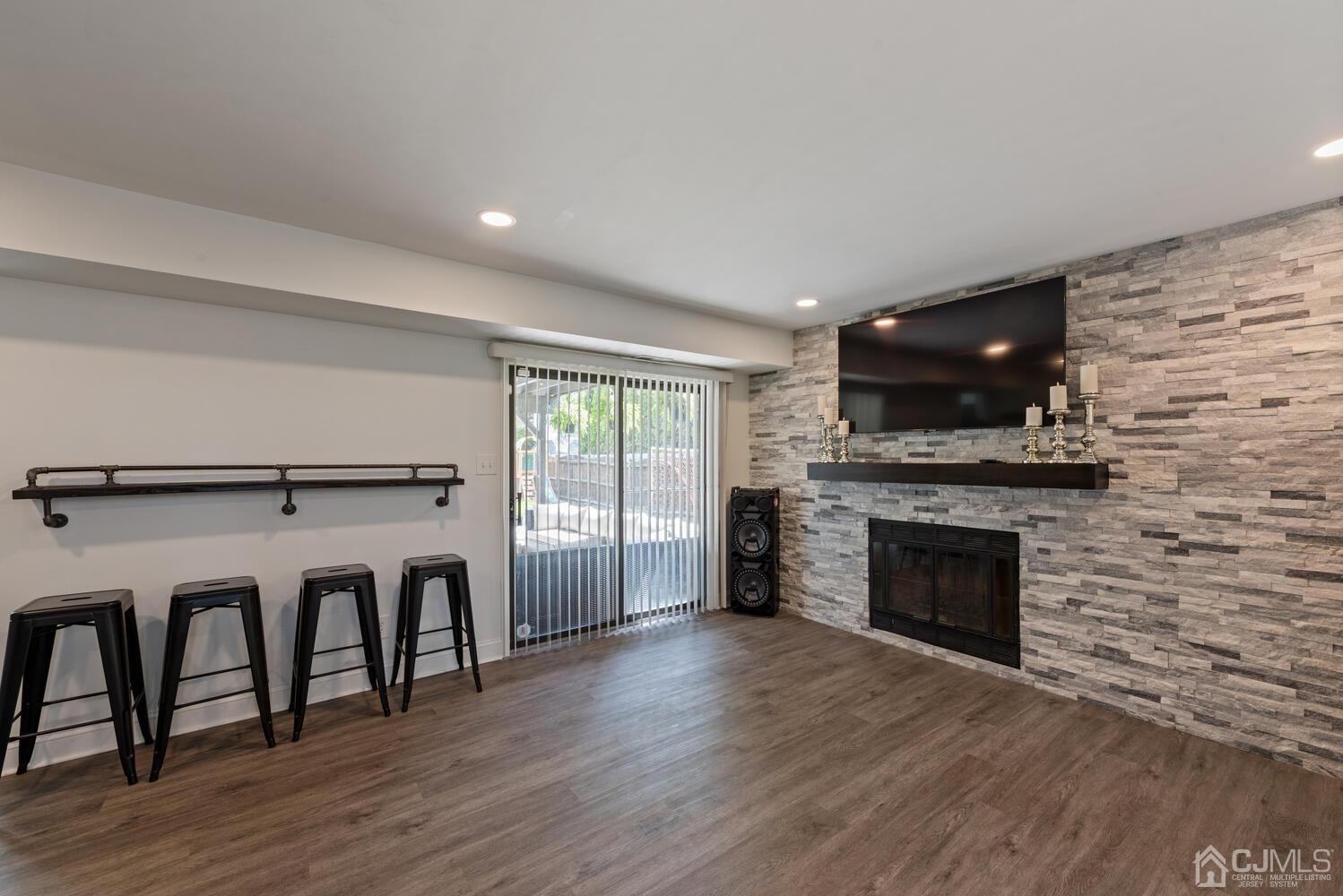 73 Appletree Road Howell, NJ 07731 - Photo 22 of 43 a living room with a fireplace and a flat screen tv