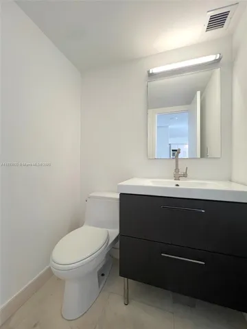 a bathroom with a sink a toilet and mirror