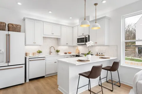 a kitchen with stainless steel appliances granite countertop a sink a stove a refrigerator and island with wooden floor