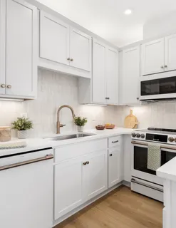 a kitchen with granite countertop white cabinets and white appliances