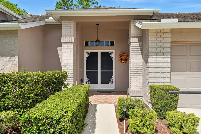 a front view of a house with a large window and potted plants