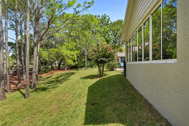 an aerial view of residential houses with outdoor space and trees