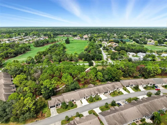an aerial view of a city with lots of residential buildings ocean and mountain view in back