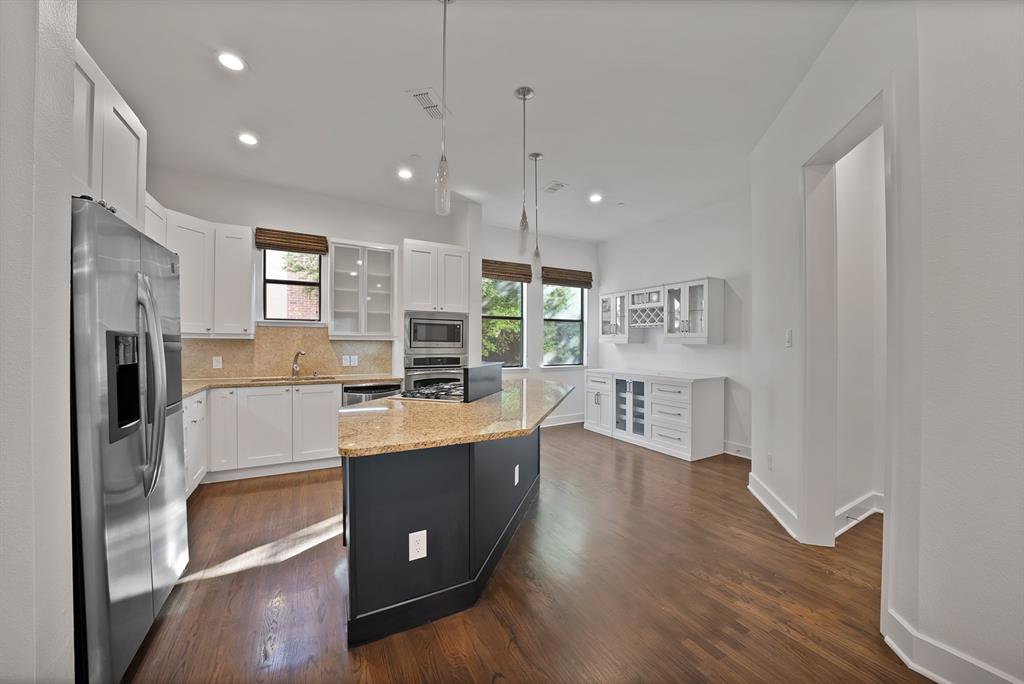 2420 Hugo Street, Unit 3 Dallas, TX 75204 - Photo 15 of 36 a large kitchen with kitchen island a large counter top space a sink stainless steel appliances and cabinets
