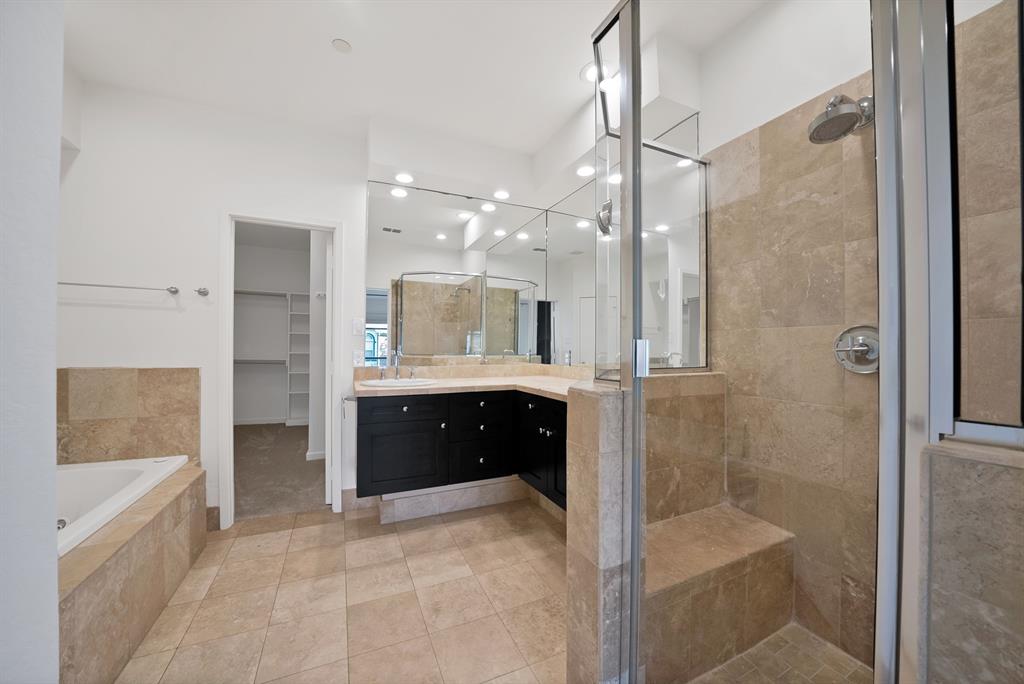 2420 Hugo Street, Unit 3 Dallas, TX 75204 - Photo 24 of 36 a bathroom with a glass shower sink vanity and mirror