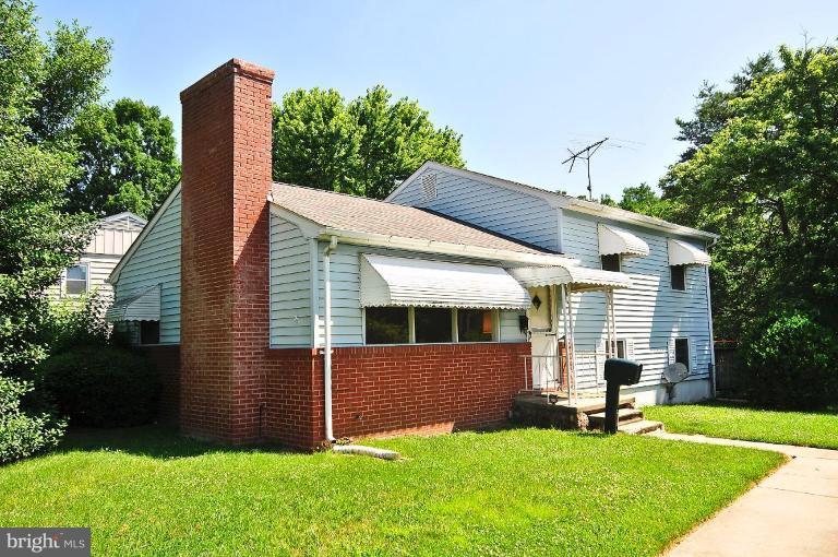 a view of a house with backyard and a tree