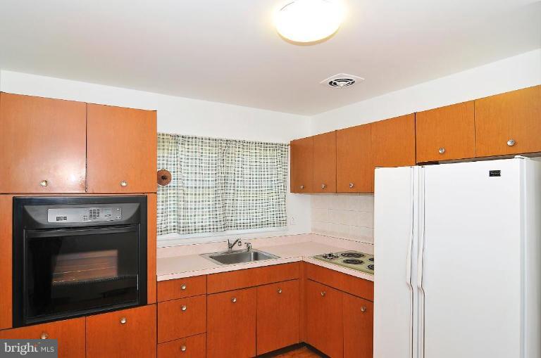 5729 Oakland Road Halethorpe, MD 21227 - Photo 8 of 18 a kitchen with a sink a stove and a refrigerator
