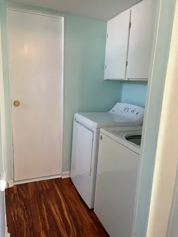a utility room with wooden floor washer and dryer